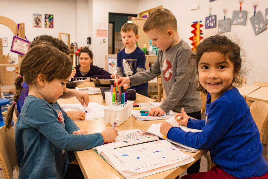 A WSU works with a group of young kids in the WSU Children's Center.