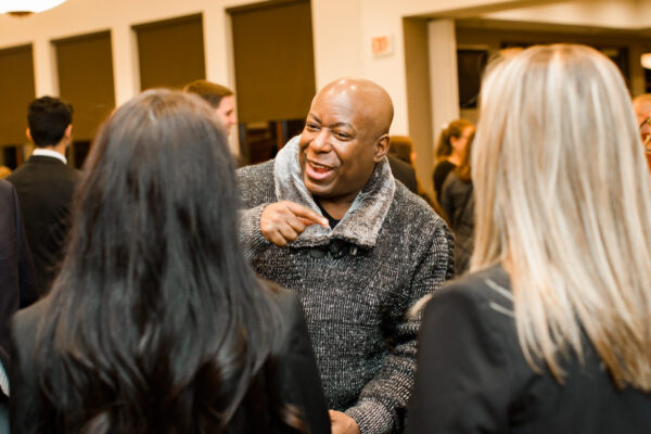 A man talks with two women at a campus event.