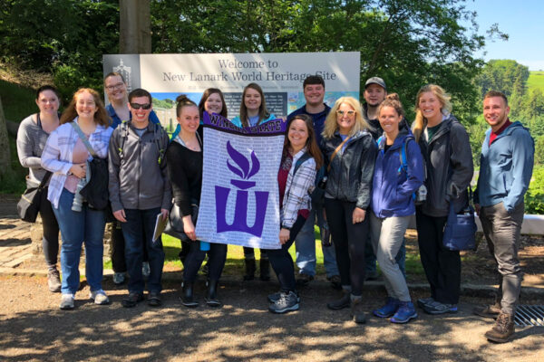 A group of WSU students and faculty pose together while visiting a heritage site.