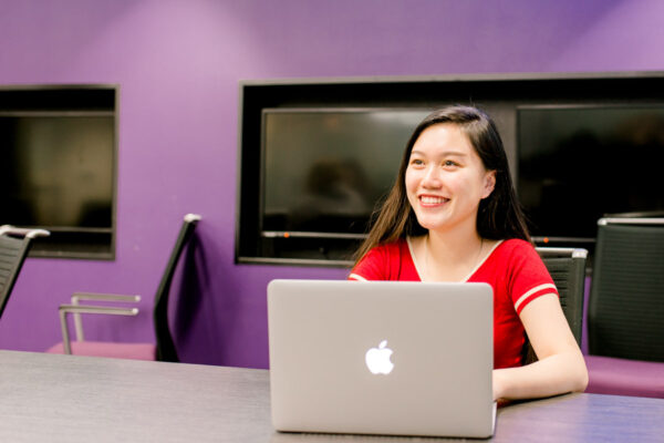 A female student works on a laptop in the Sales Center at the Winona campus.