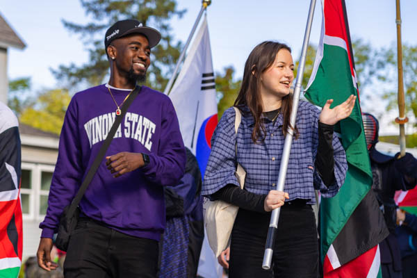 WSU international students holding flags during parade.