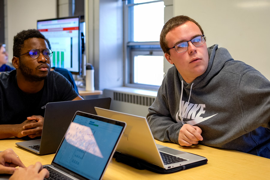 WSU students sitting at a table with their laptops.