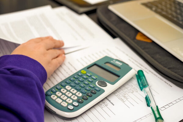 WSU student sitting at a table with a laptop and calculator.