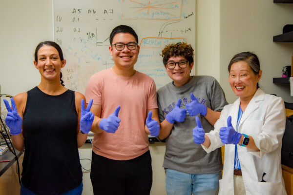 Student researchers and faculty mentor in front of a whiteboard.