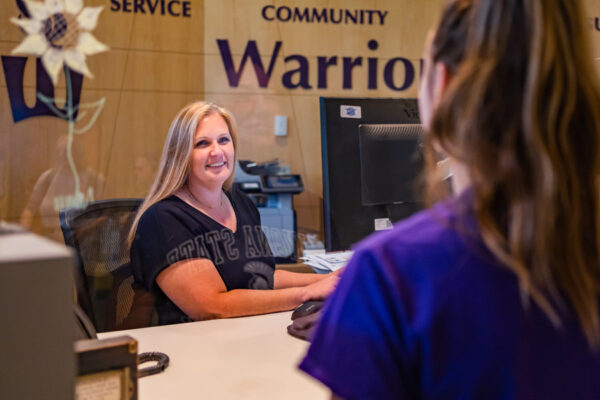 A staff member helps a student in the Warrior Hub on the WSU campus.