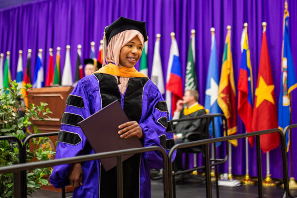 A master's graduate walks across the stage during the WSU Commencement Ceremony.