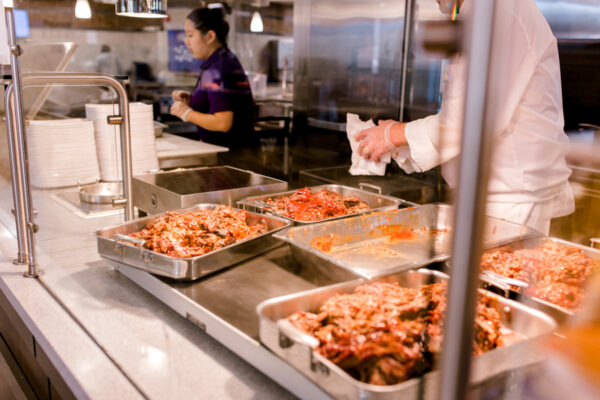 An employee prepares food at a station in the Jack Kane Dining Hall on WSU campus.