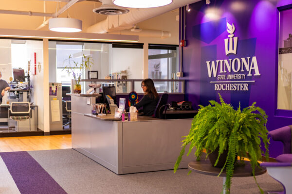 A female employee works on a computer in an office at the WSU Rochester campus.