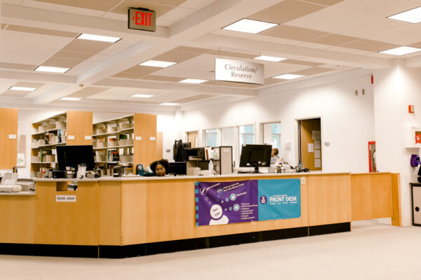 A student worker sits at the Circulation & Reserves desk in the Krueger Library on the WSU campus.