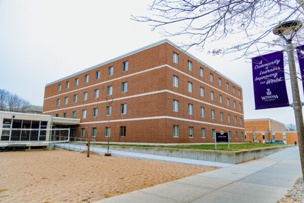 The exterior of Prentiss-Lucas and a sand volleyball court on the WSU campus.