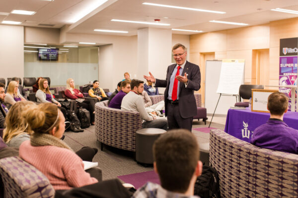 A guest speaker presents to a group of students in the College of Business Engagement Center.