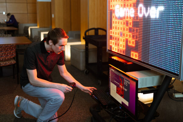 A student inspects a computer in a classroom.