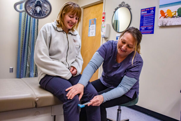 A nurse practitioner gives a student a physical exam.