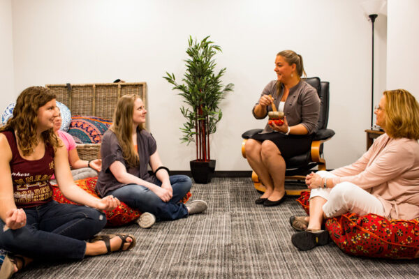 Students sit in a circle on the floor for a discussion during class.