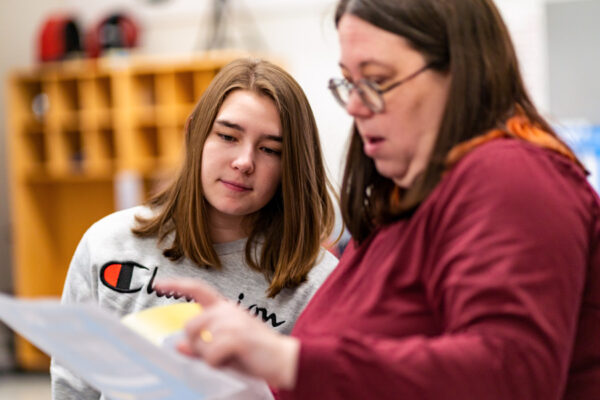 A student discusses an assignment with a professor.