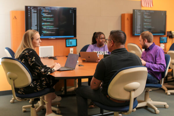 A group of students work on a computer science project in a classroom.