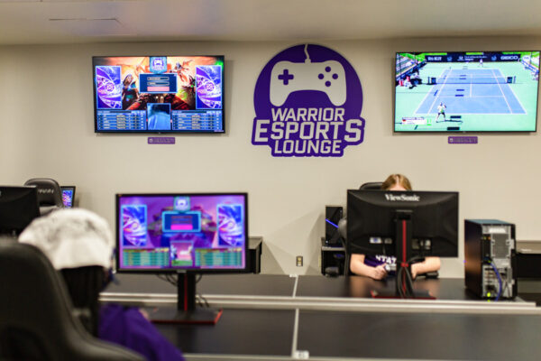 Two WSU students play pc and console video games in the Warrior Esports Lounge.